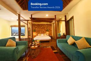 a living room with two green couches and a bed at Woodapple Hotel and Spa in Kathmandu