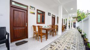 a dining room with a wooden door and a table and chairs at Near Town Lodge in Dambulla