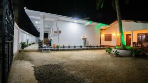 a white building with green lights on it at night at Near Town Lodge in Dambulla