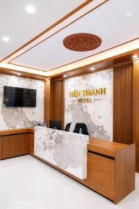 a reception desk in a hotel lobby with a sign that reads ten frame hotel at Tiến Thành Hotel Nghệ An in Vinh