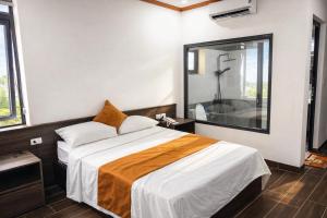 a bedroom with a large bed and a large mirror at Tiến Thành Hotel Nghệ An in Vinh