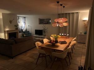 a living room with a table and chairs and a couch at Duinvilla met sauna en whirlpool in Makkum