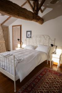 a bedroom with a white bed and a rug at Domaine de charme pour groupes et evenement in Chillac