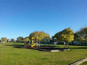 a park with a playground with a slide at Tudor Park Motel in Gisborne