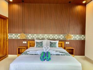 a bedroom with a bed with blue shoes on it at Moonlight Heaven Villa Ubud 2BR Private Pool in Tampaksiring +8 photos