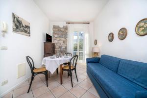 a living room with a blue couch and a table at Residence in Villa Giulia in Grado
