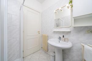 a white bathroom with a sink and a mirror at Residence in Villa Giulia in Grado