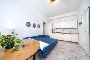 a kitchen with a table and a blue couch in a room at Residence in Villa Giulia in Grado +12 photos