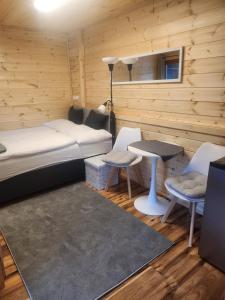 a room with a bed and a table and chairs at Pici vendégház in Noszvaj
