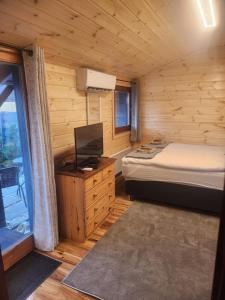 a bedroom with a bed and a television in a cabin at Pici vendégház in Noszvaj