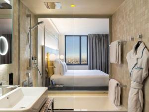 a bathroom with a bed and a tub and a sink at Pullman Paris Montparnasse in Paris