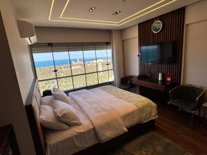 a bedroom with a bed and a large window at Sheraton Palace Sea View in Alexandria
