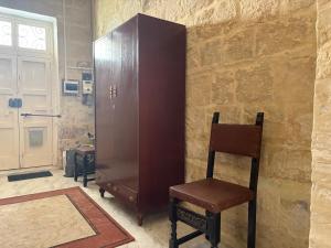 a wooden cabinet and a chair in a room at Guesthouse 39 in Mqabba +9 photos