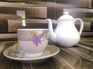 una tazza e un vaso su un tavolo di legno di Eden Blue Hikkaduwa a Hikkaduwa Altre 37 foto