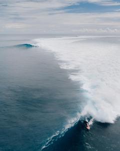 a person riding a wave in the ocean at La La Villas in Pulau Pototogat +1 photo