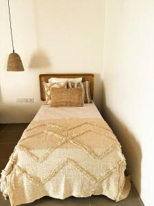 a bedroom with a bed with a blanket and pillows at La La Villas in Pulau Pototogat