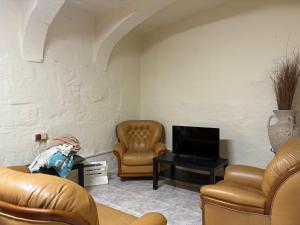 a living room with two chairs and a television at Guesthouse 39 in Mqabba
