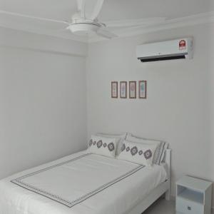 a white bedroom with a bed and a ceiling fan at MZ Homestay Kampar in Kampar
