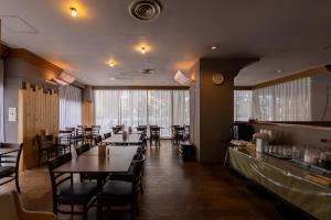 a dining room with tables and chairs in a restaurant at Court Hotel Asahikawa in Asahikawa