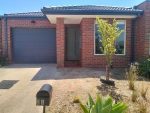 a parking meter in front of a house with a garage at Comfort and good value in Melton South