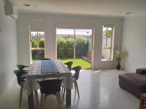 a dining room with a table and some chairs at Comfort and good value in Melton South