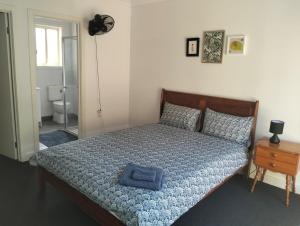 a bedroom with a bed with a blue towel on it at Comfort and good value in Melton South