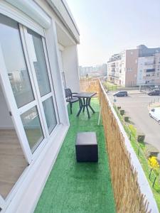 a balcony with green grass and a table at Eves Rooms in Saint-Michel-sur-Orge +8 photos