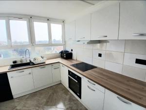 a white kitchen with white cabinets and a sink at Eves Rooms in Saint-Michel-sur-Orge