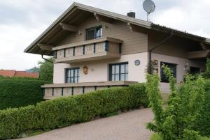 a house with a balcony on a brick driveway at Ferienwohnung Michael Vogl in Bodenmais
