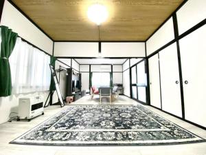a living room with a large rug on the floor at comodo inn HANAZONO in Aomori