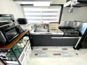 a small kitchen with a sink and a stove at comodo inn HANAZONO in Aomori +23 photos