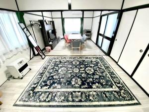 a view of a living room with a rug on the floor at comodo inn HANAZONO in Aomori