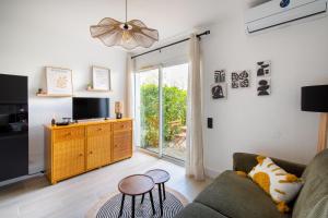 a living room with a couch and a tv at Jardin du Golf wifi Clim in La Grande Motte +32 photos