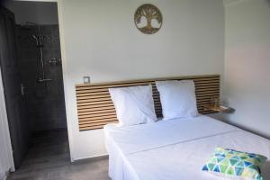 a bedroom with a white bed and a shower at La kaz a sonel, gîte au vert in Morne-à-lʼEau