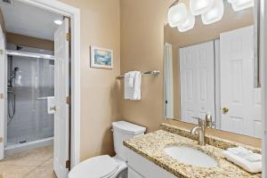 a bathroom with a toilet and a sink and a mirror at Windancer 110 in Destin
