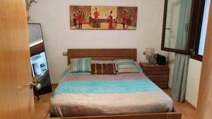 ein Schlafzimmer mit einem Bett und einem Gemälde an der Wand in der Unterkunft Carudo in Llafranc