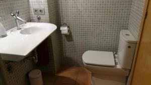 ein Badezimmer mit weißer Toilette und Waschbecken in der Unterkunft Carudo in Llafranc
