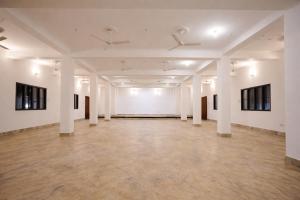an empty room with white walls and white columns at Gangabagh by Divine Trails - Hotel Near Har Ki Pauri, Haridwar in Haridwār