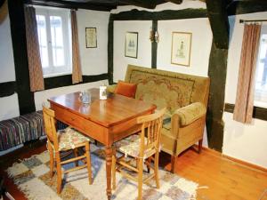 a dining room with a table and chairs and a couch at Traditionelles Ferienhaus in Hessen mit Garten in Willingshausen