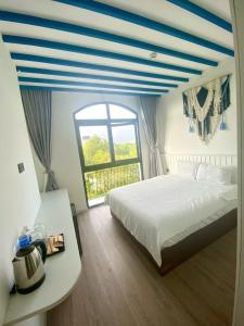 a bedroom with a bed and a large window at UY LONG Homestay Grand World Phú Quốc in Phú Quốc