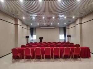 a conference room with a red table and red chairs at Yihe Hotel Luoyang in Luoyang