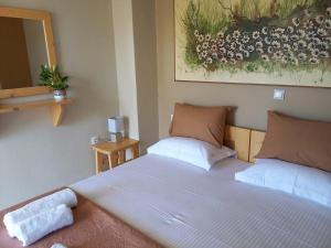 a bedroom with two beds and a mirror at Mulberry house in Elafonisos