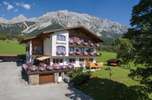 a large building with flowers on the front of it at Sonnhof in Ramsau am Dachstein