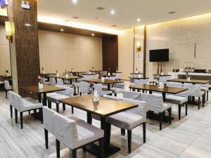 a dining room with tables and white chairs at Yihe Hotel Luoyang in Luoyang