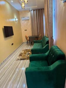 a living room with green couches and a table at Unique CityLife Hotel in Etoi