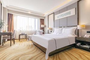 a bedroom with a large white bed and a desk at Yihe Hotel Luoyang in Luoyang