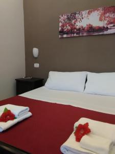 Una habitación de hotel con una cama con toallas y flores. en Cusmano Residence, en Catania
