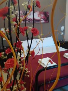 una mesa con flores rojas delante de una mesa en Cusmano Residence, en Catania