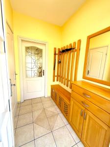 a yellow room with a door and a tiled floor at Aurora Premium Home in Győr