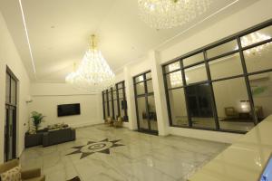 a large living room with a chandelier and a large room with a floor at Corbett Caves in Rāmnagar